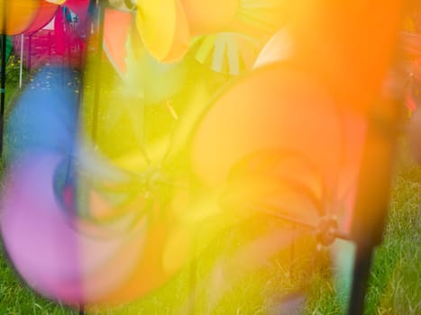 colorful rotating children's wind turbines recorded on a meadow with long exposure time