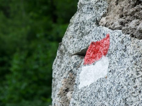 Close-up of a red-and-white hiking trail on granite in the South Tyrolean Alps in daylight in summer