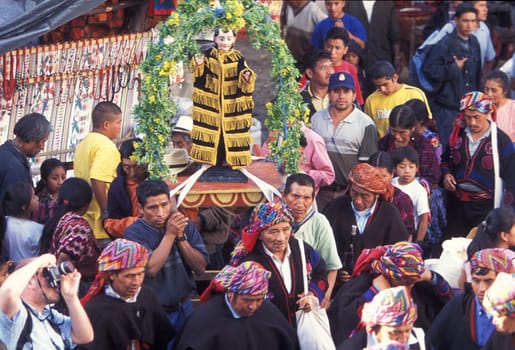 A relogion procession with people in traditional clotes at the Market in the Village of Chichi or Chichicastenango in Guatemala in central America.