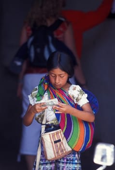 a child with money from tourists in the old town in the city of Antigua in Guatemala in central America.