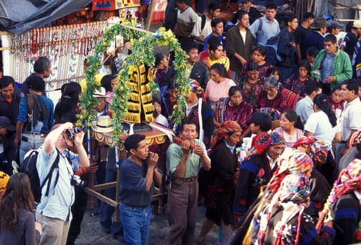 A relogion procession with people in traditional clotes at the Market in the Village of Chichi or Chichicastenango in Guatemala in central America.