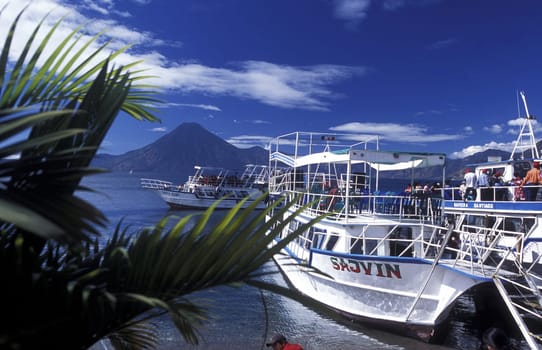 People at the coast of Lake Atitlan mit the Volcanos of Toliman and San Pedro in the back at the Town of Panajachel in Guatemala in central America.