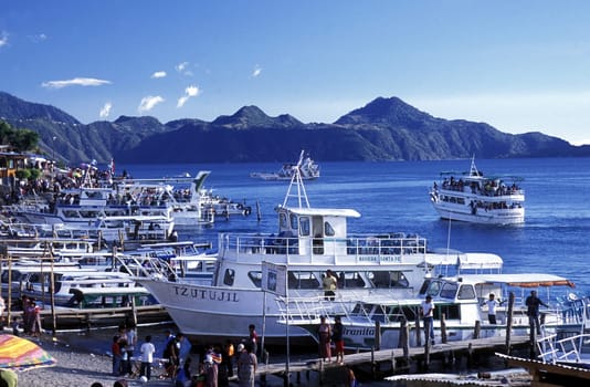 People at the coast of Lake Atitlan mit the Volcanos of Toliman and San Pedro in the back at the Town of Panajachel in Guatemala in central America.