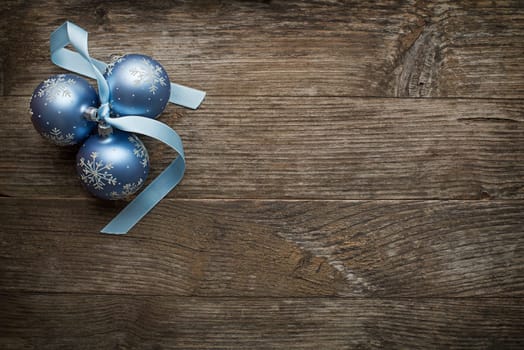 Christmas ornaments with silk ribbon on wooden background