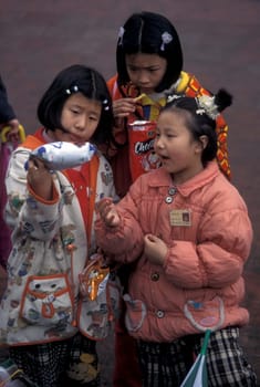 childern with some snaks on the streets of Chongqing in the province of Sichuan in china in east asia.