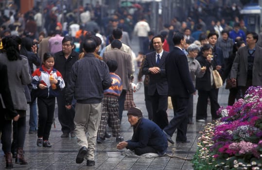 a poor wonen at a shopping street in the city of Chongqing in the province of Sichuan in china in east asia.