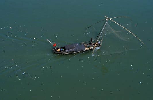 a fishing boatin the yangzee river in the city of yichang near the three gorges dam project in the province of hubei in china.