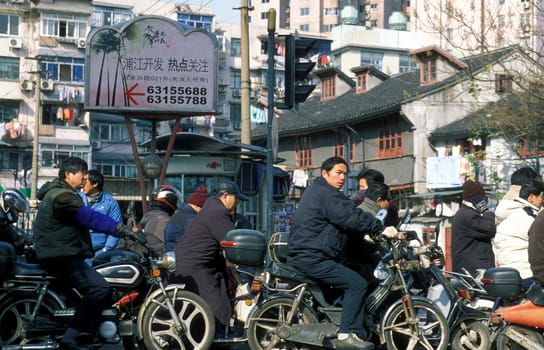people in the trafic line in the City of Shanghai in china in east asia.