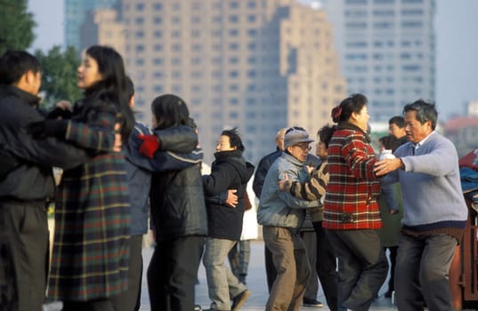people dancing in the morning on the Bund in front of the skyline of Pudong in the City Shanghai in China.
