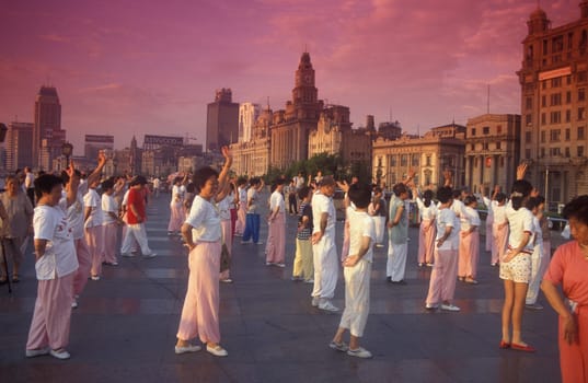 people dancing in the morning on the Bund in front of the skyline of Pudong in the City Shanghai in China.