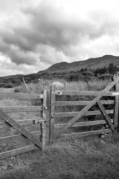 chained fence with mountains at the background in black and white