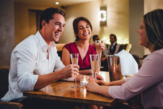 Group of friends enjoying a bottle of champagne in a restaurant.