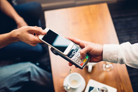 Business man making a contactless smartphone payment.