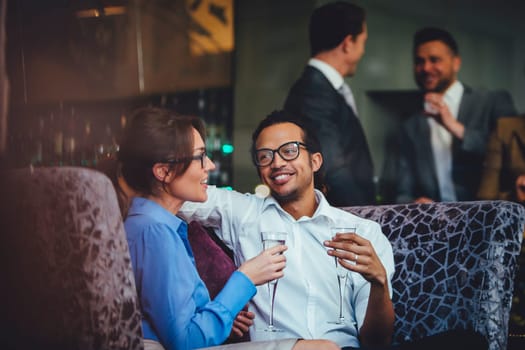 Couple enjoying a glass of champagne after work together at a bar.