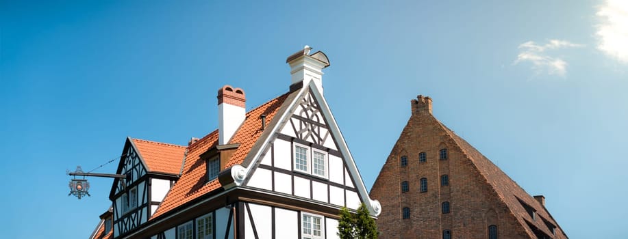 Old half-timbered  house and medieval grand mill in street of Gdansk, Poland, Europe. Beautiful sunny day, old building. German style in architecture.