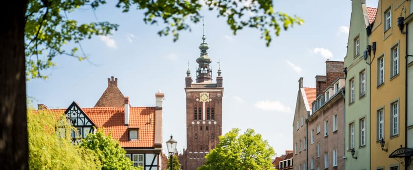 Old houses and tower clock museum panorama of Gdansk, Poland, Europe. Beautiful sunny day, old building. German style in architecture.