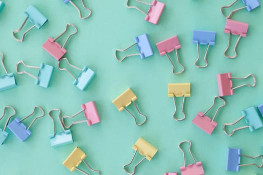 Colorful paper clips in pastel colors as flatlay background