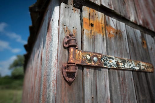 Closeup of an old rusty hinge on a boathouse