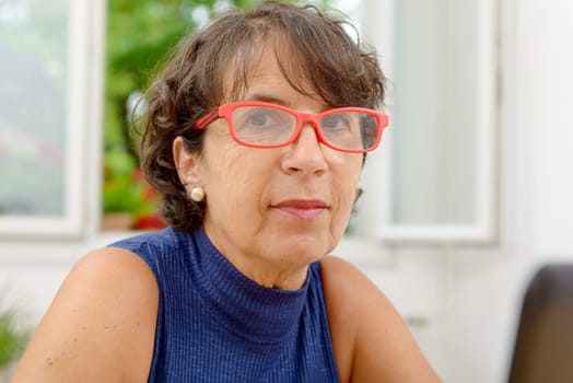 portrait of a beautiful mature woman with red glasses