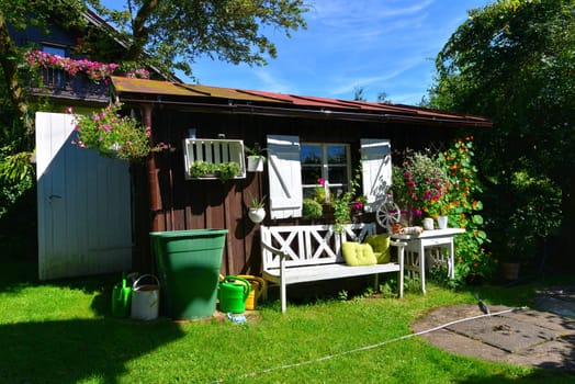 Garden hut in summer with lots of flowers