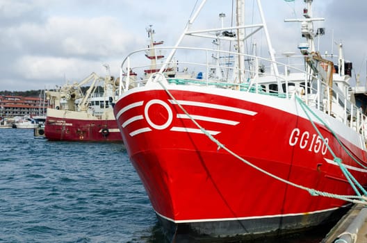 one red fishing boat in harbour redy to go out and catch the fish