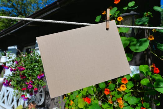 Sheet of paper on clothesline in front of colorful flowers
