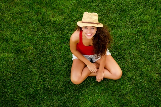 Outdoor portrait of a beautiful young woman lying on the grass