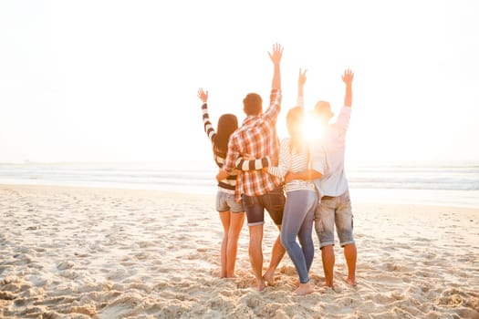 Group of friends at the beach and looking back