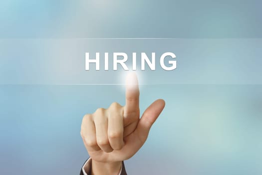 business hand pushing job hiring button on blurred background