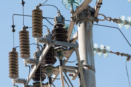 Electric pole connect to the high voltage electric wires on blue sky background.
