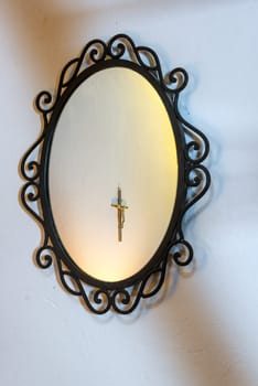 Mirror with a cross with Jesus on it in the reflection in Villa de Leyva, Colombia