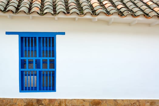 Facade of a historic colonial building with a blue window in Villa de Leyva, Colombia