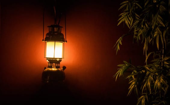 Light lantern on the wall next to a tree at night for a background