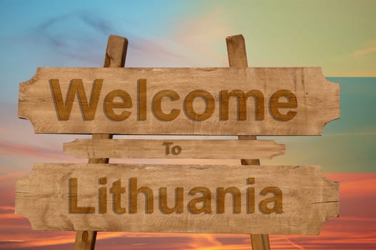 welcome to lithuania sign on wood background with blending national flag