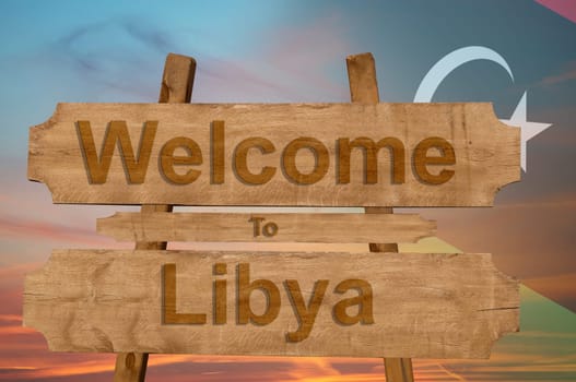 welcome to libya sign on wood background with blending national flag