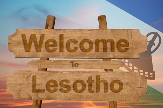 welcome to lesotho sign on wood background with blending national flag