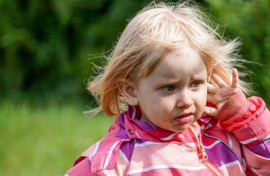 Sad little girl outside in the Garden