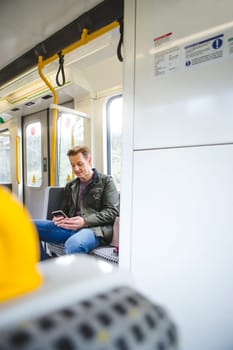 Man sitting on the train using his smart phone.