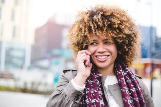 Woman in the city. She is talking on the phone.