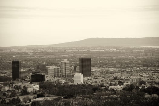 The skyline of Los Angeles with various high-rise buildings in the city center surrounded by parks and infrastructure.