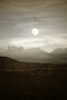 Cloud bands as well as the moon over the mountains between Amaragosa Valley and Las Vegas.