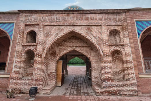 The imposing entrance of the Imamzadeh Mausoleum complex in Ganja, Azerbaijan, is adorned with intricate brickwork and vibrant tile designs, reflecting the country's rich cultural heritage