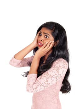 A lovely young Indian woman holding both hands on her face and looking.very scared, isolated for white background..