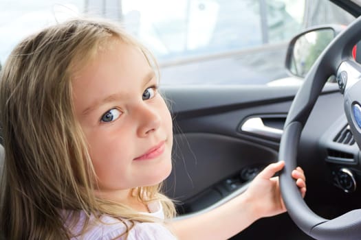 Cute girl driving car with blond long hair