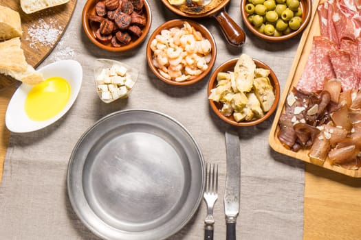 Tapas food, served in small bowls cold meat, goat cheese. A meal for sharing