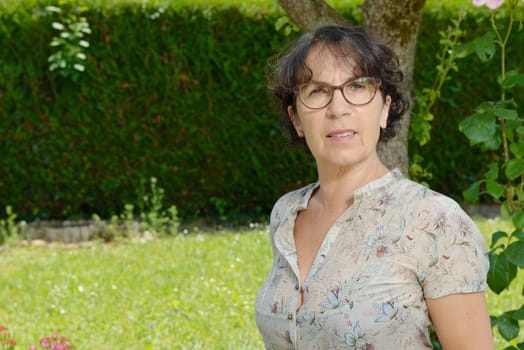 a middle aged woman with glasses in the garden