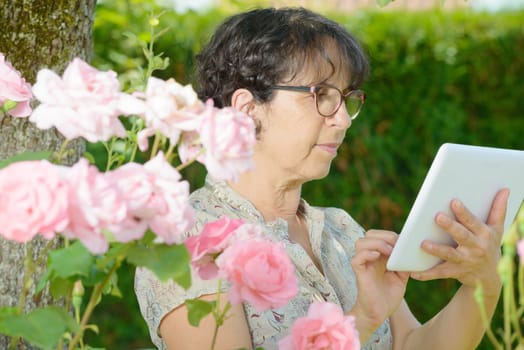 portrait of a mature woman with a tablet in his garden