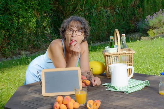 a woman eating a fruit in his garden