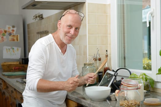a mature man smiling in the kitchen