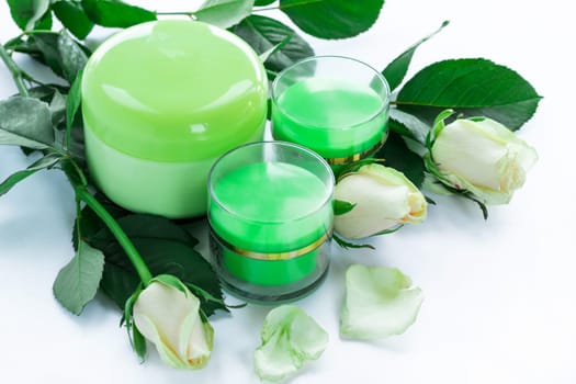 Set of three green cosmetic cream bottles with white roses